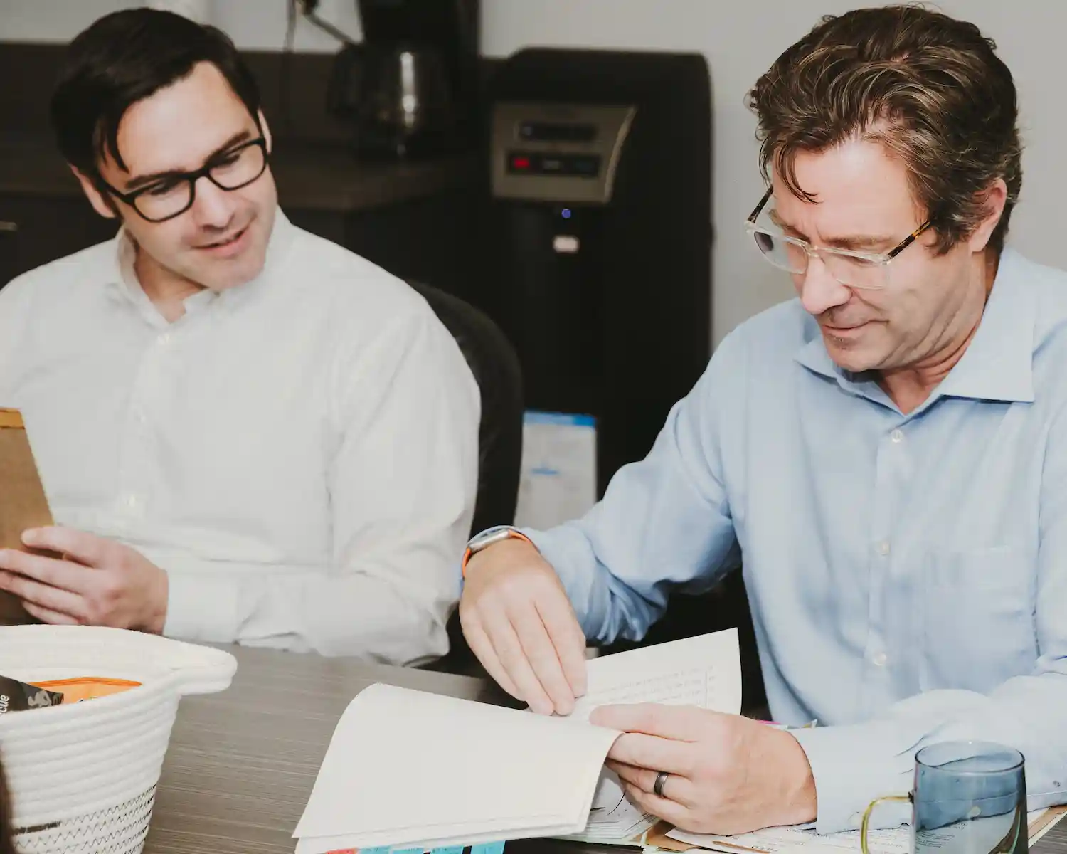 Mark Hodgson and a colleague reviewing papers at a desk