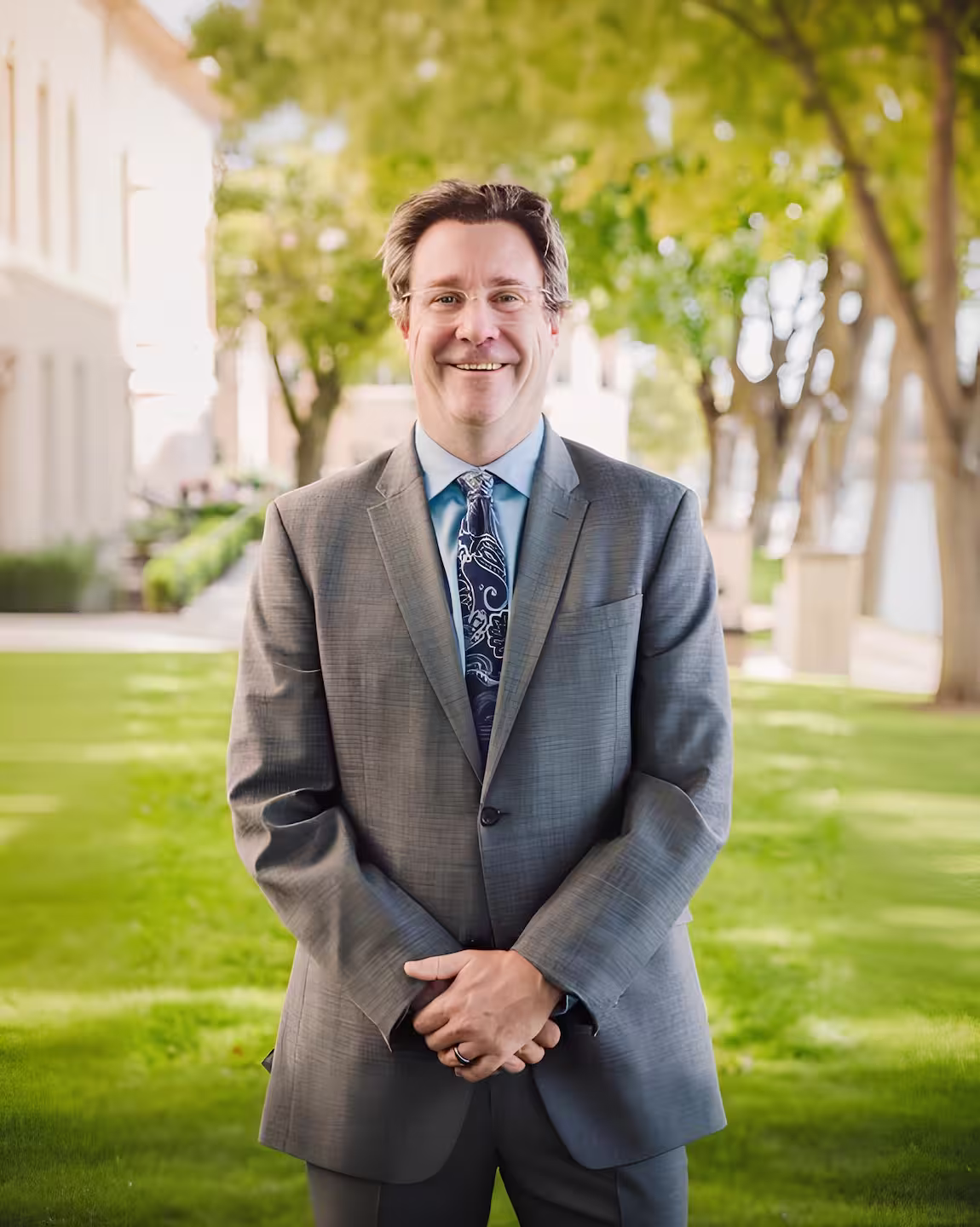 Mark Hodgson, family law attorney, smiling outdoors in a gray suit