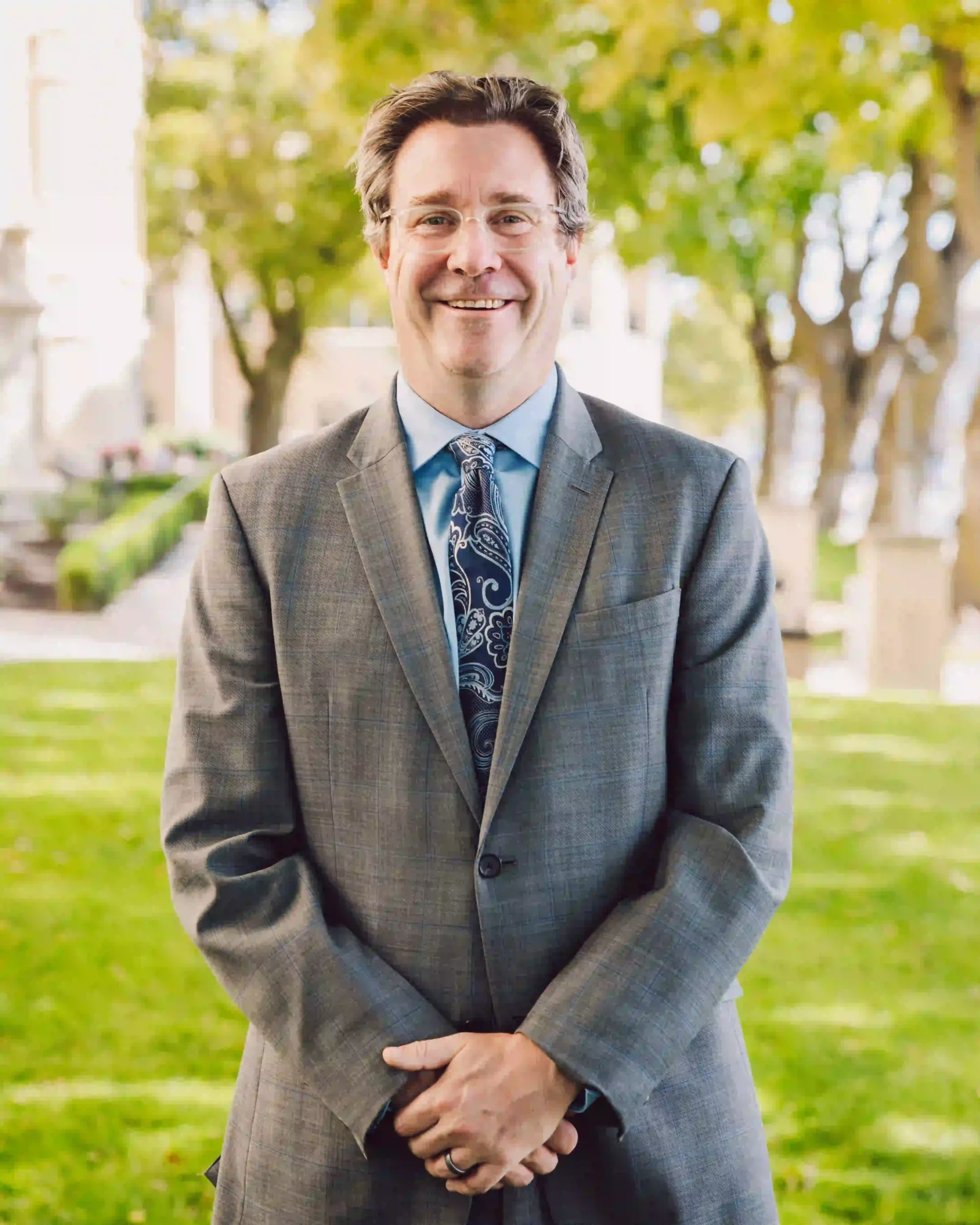 Portrait of Mark Hodgson, family law attorney, in a gray suit and blue tie